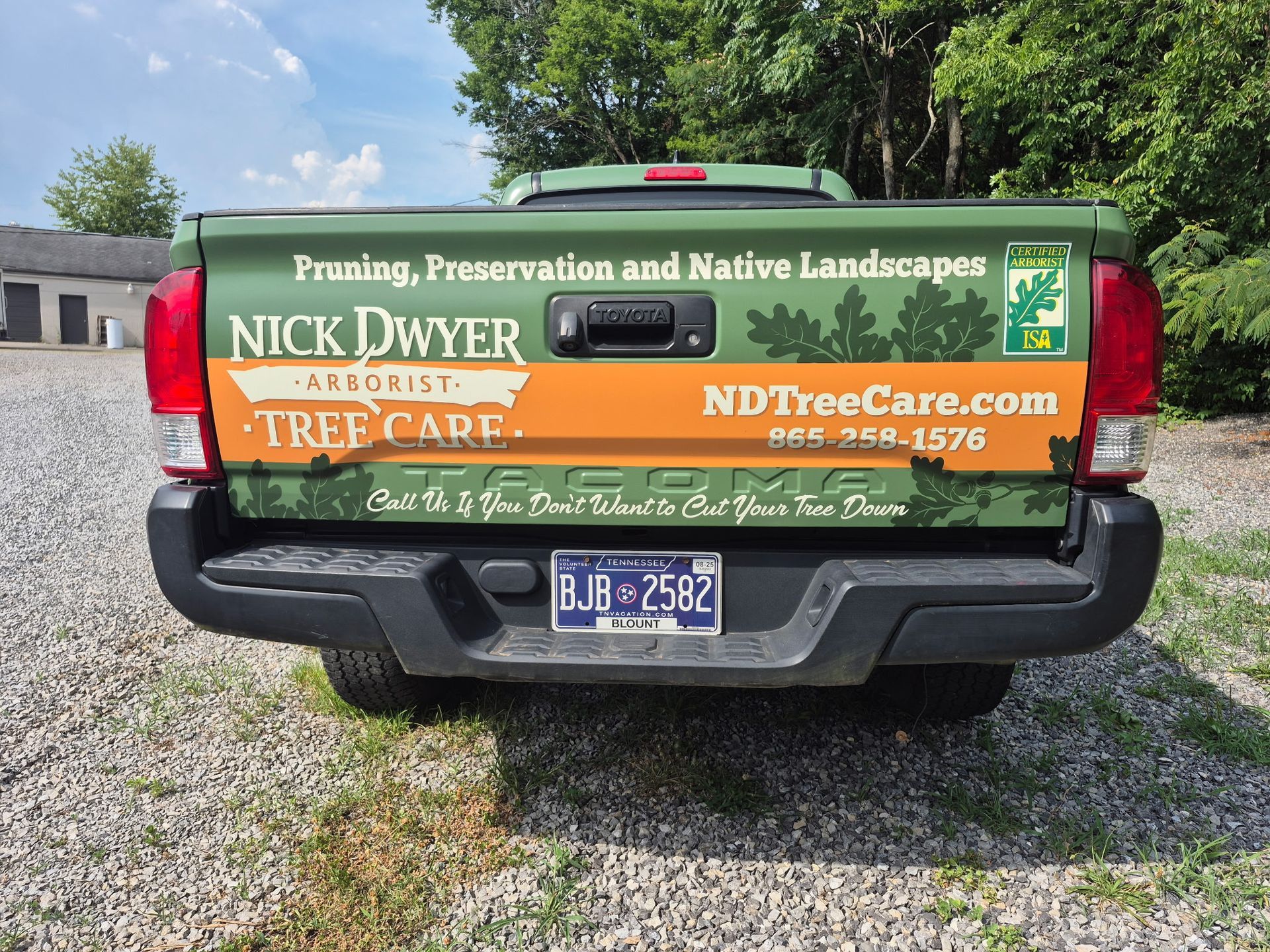 A truck with a sticker on the back that says nick dwyer tree care