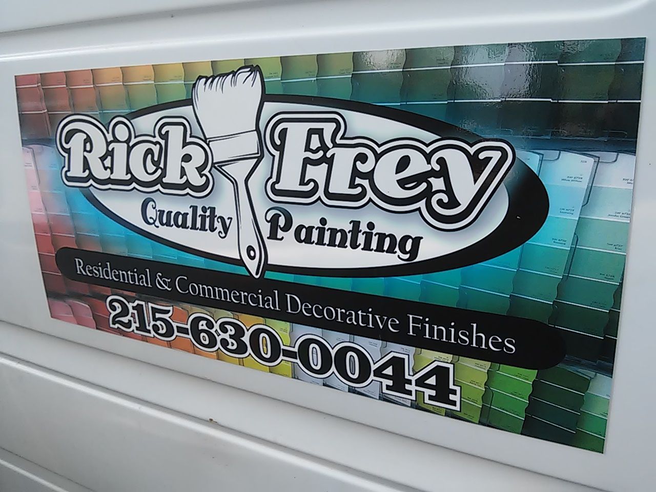 A sign for rick frey quality painting is on the side of a white van