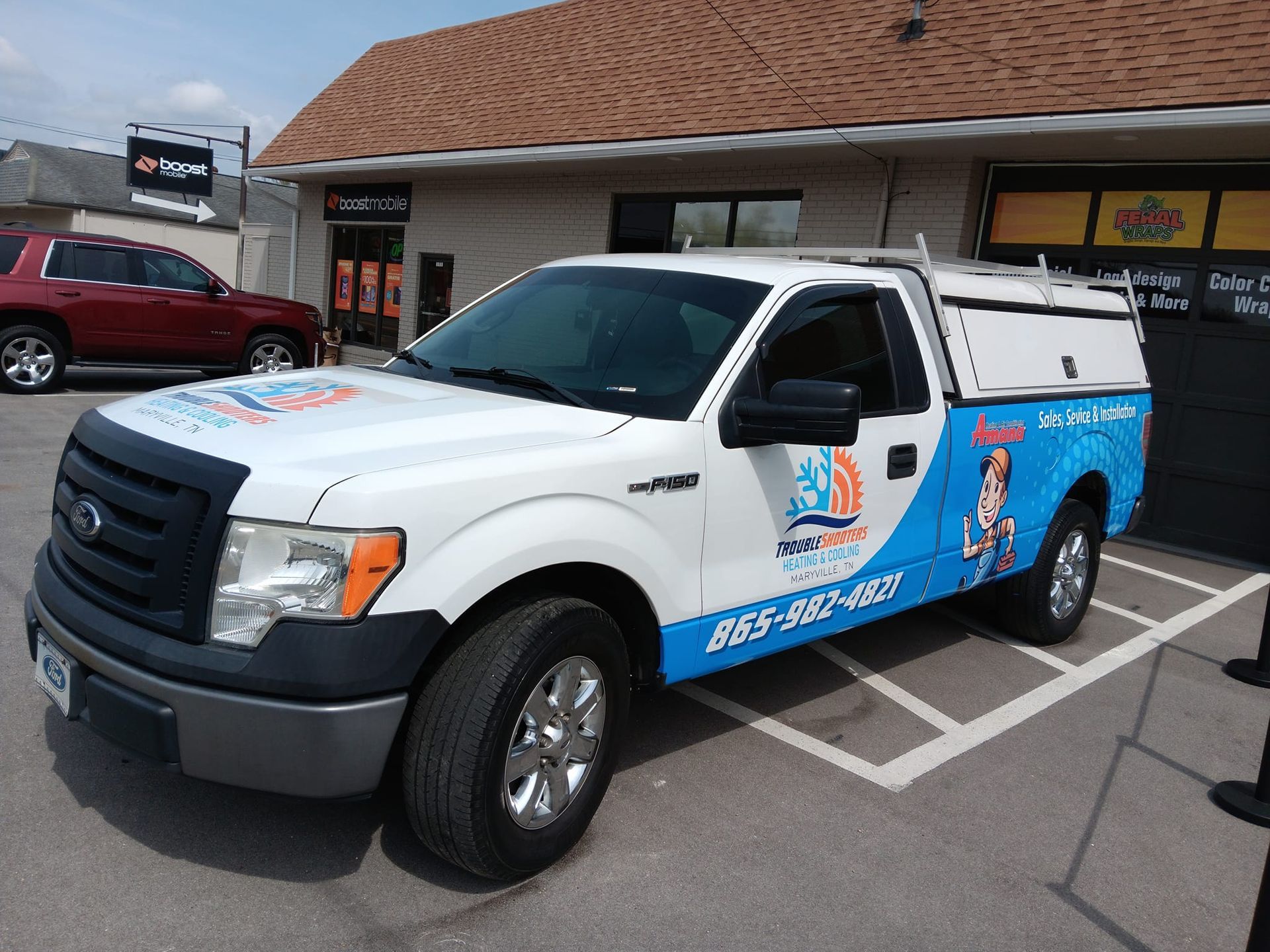 A white ford truck is parked in front of a building