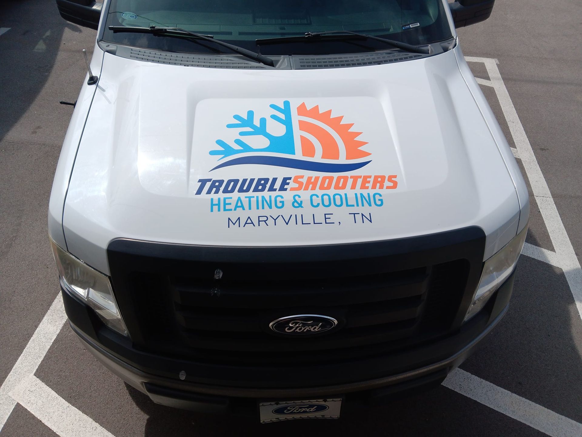 A white ford truck with the word troubleshooters on the hood