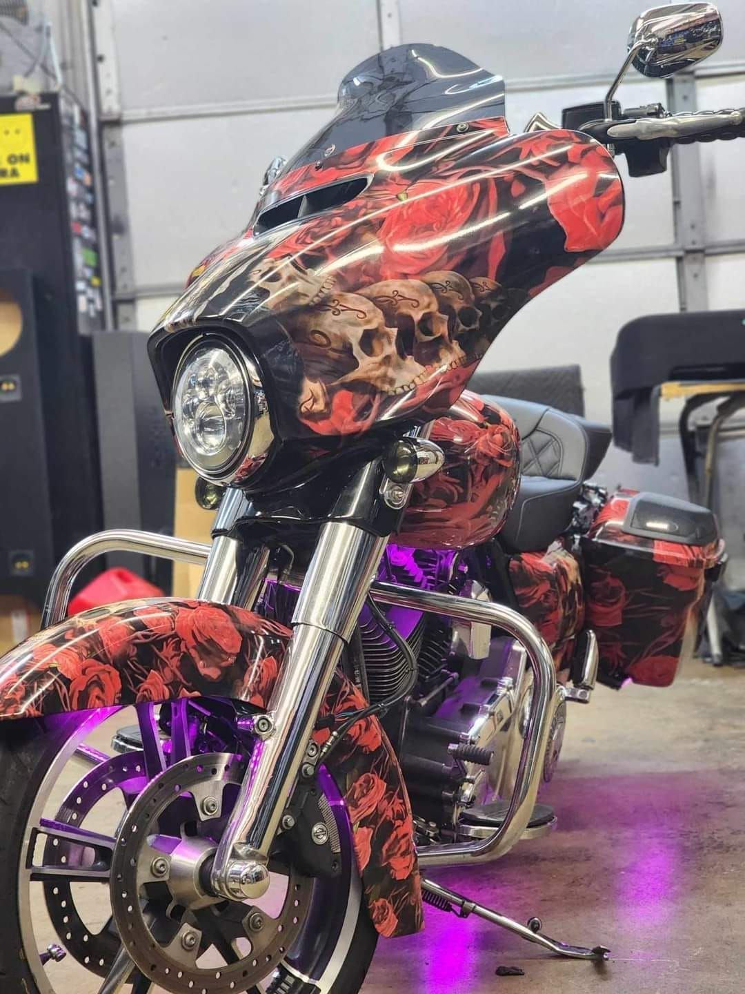 A motorcycle with skulls painted on it is parked in a garage.