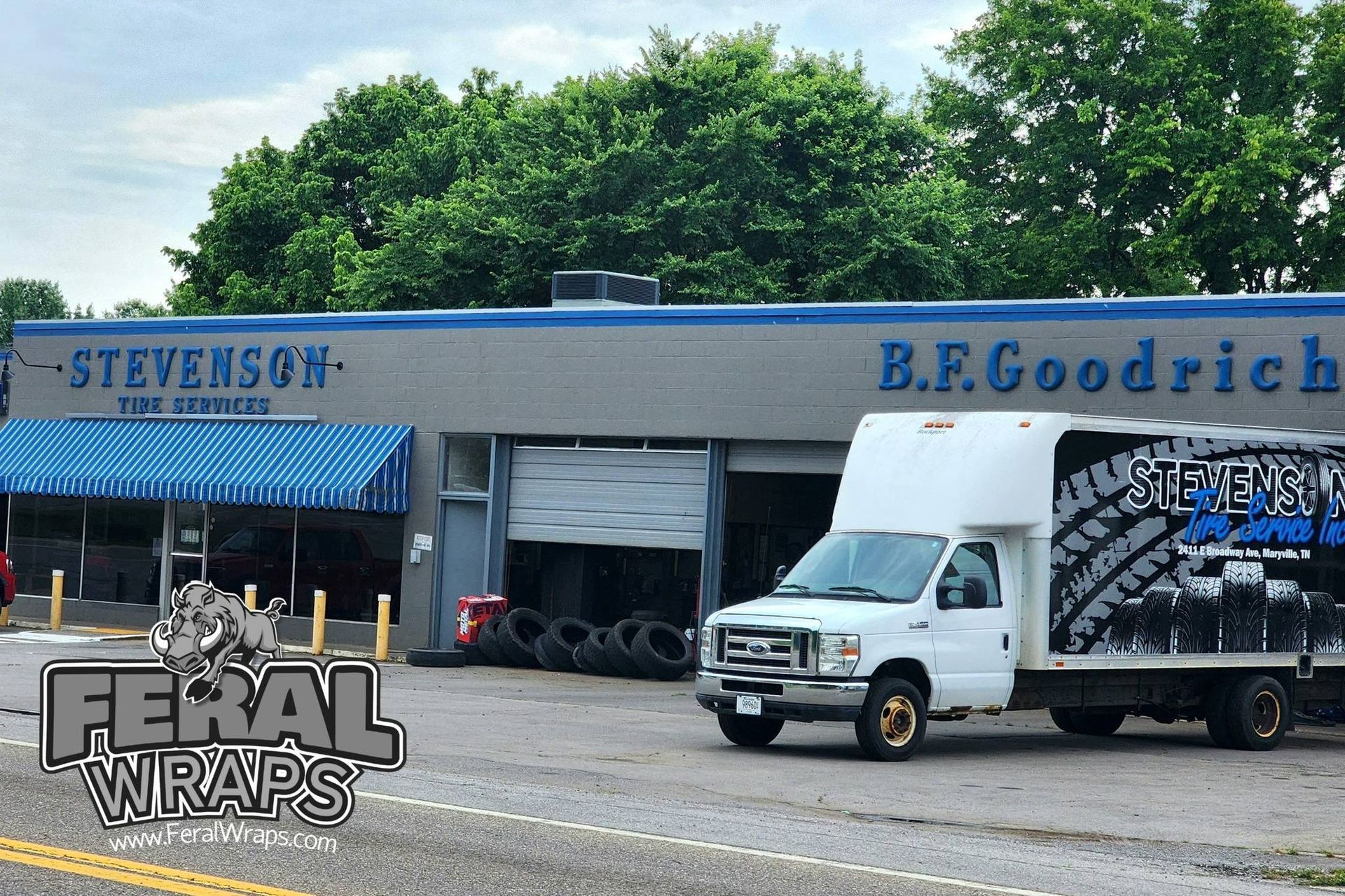 A white truck is parked in front of a building that says b.f. goodrich