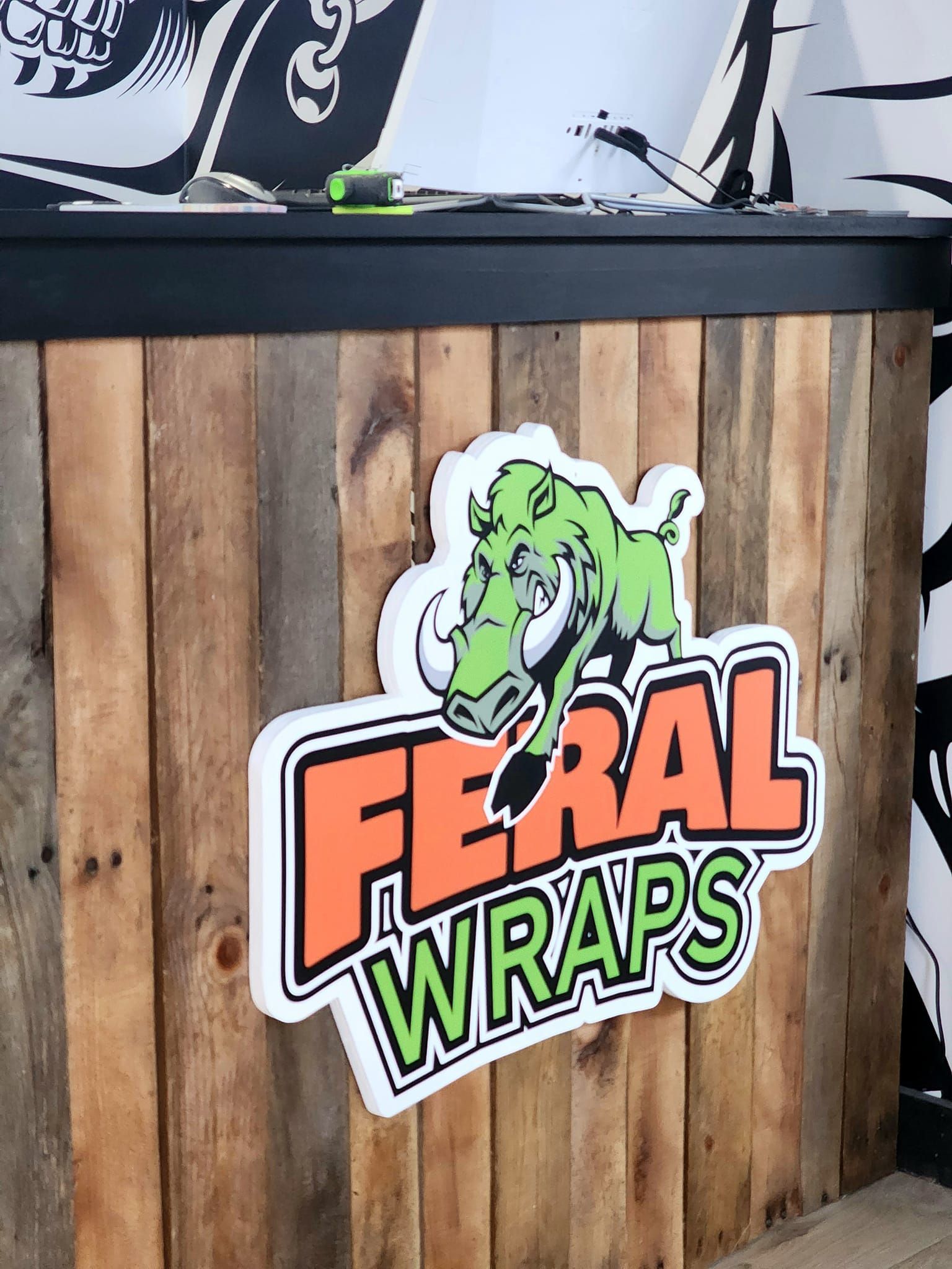 A wooden counter with a feral wraps logo on it