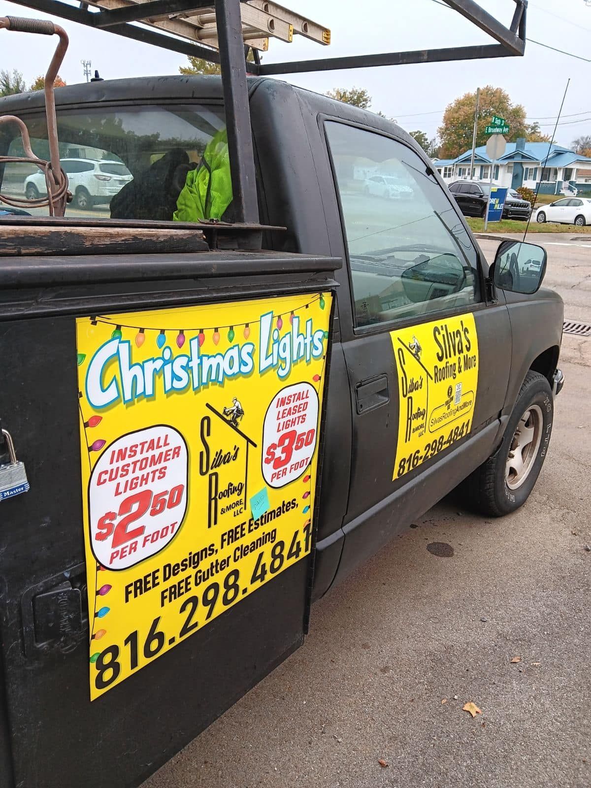 A christmas lights truck is parked in a parking lot.