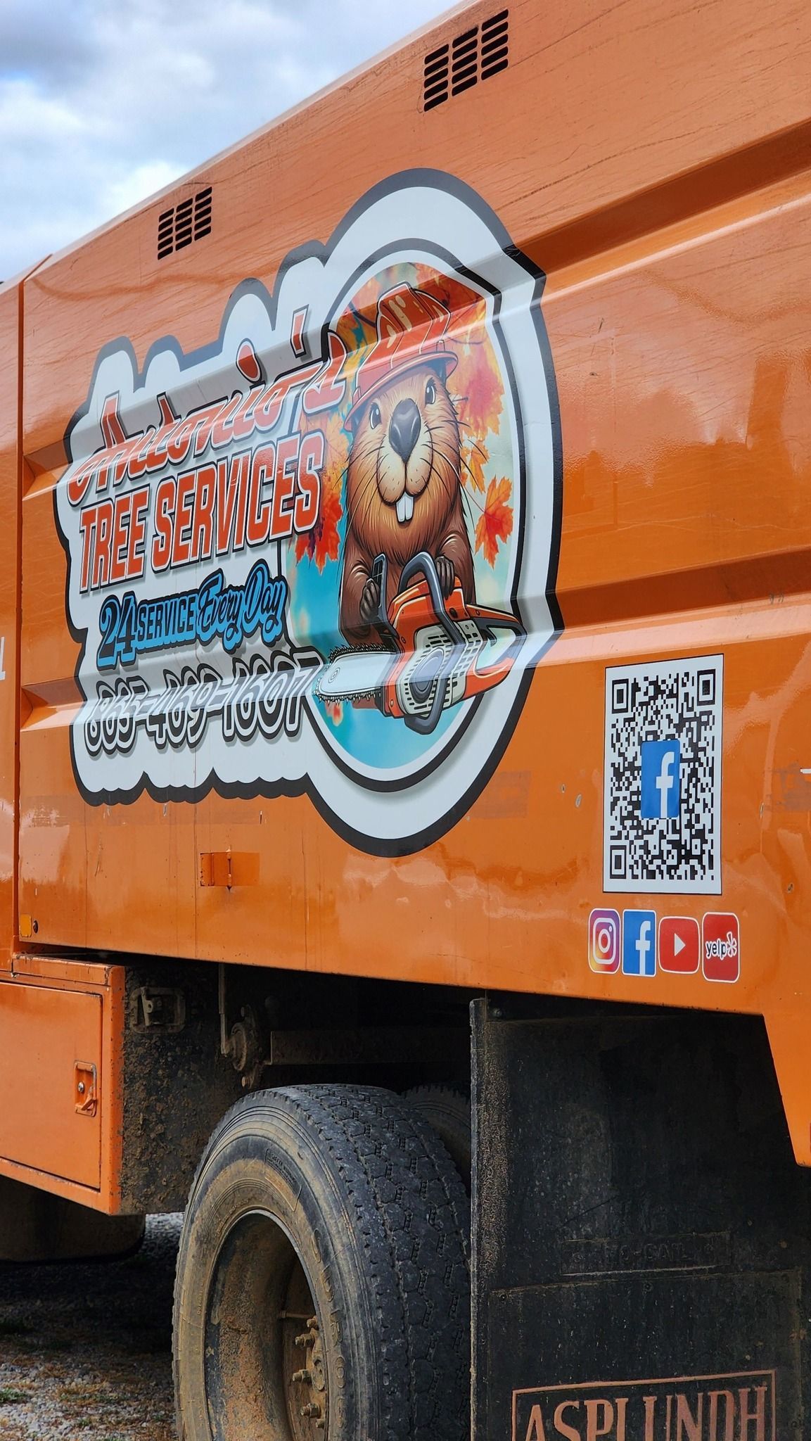 A large orange truck with a sticker on the side of it.