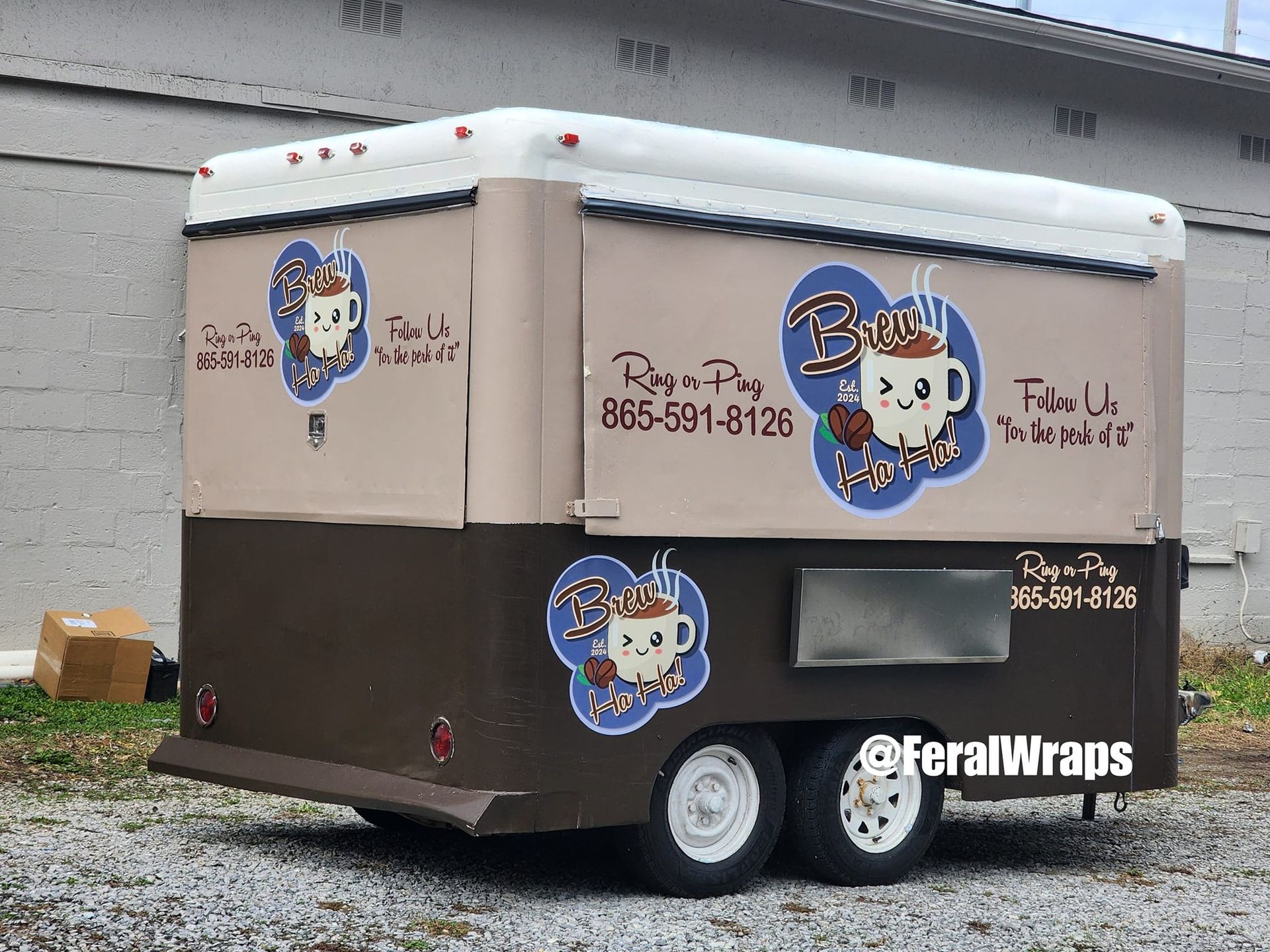 A brown and white food truck is parked in a gravel lot.