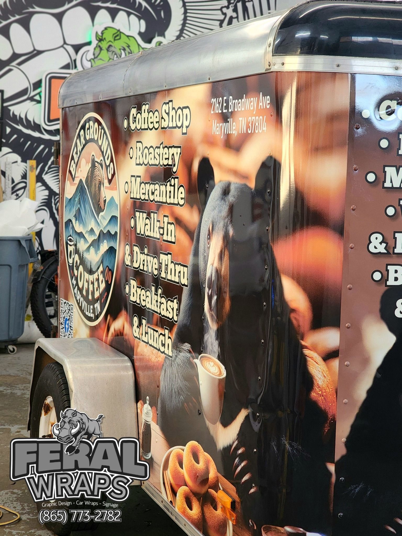 A trailer with a squirrel holding a cup of coffee and donuts on it.