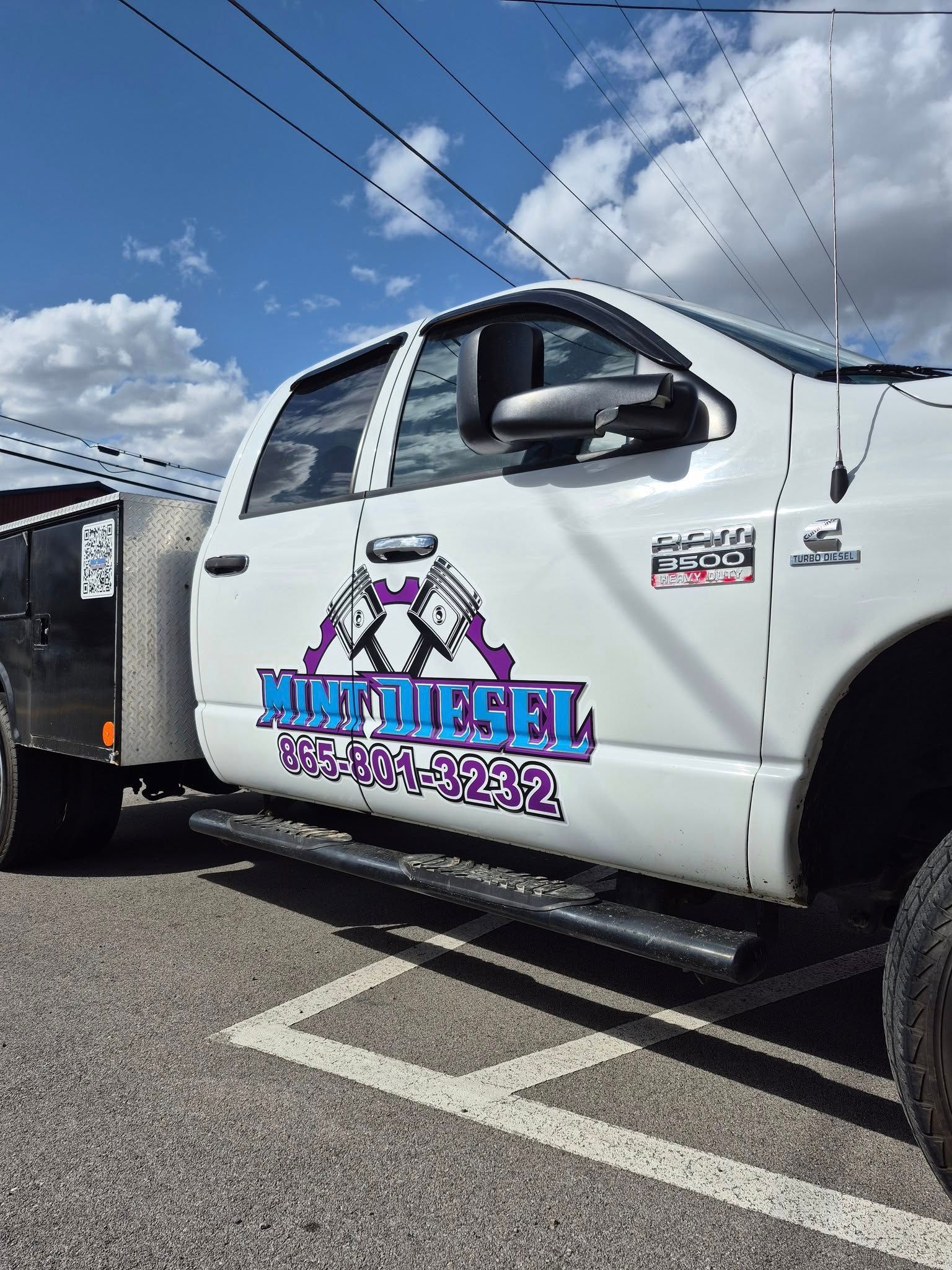 A white truck with king diesel written on the side is parked in a parking lot