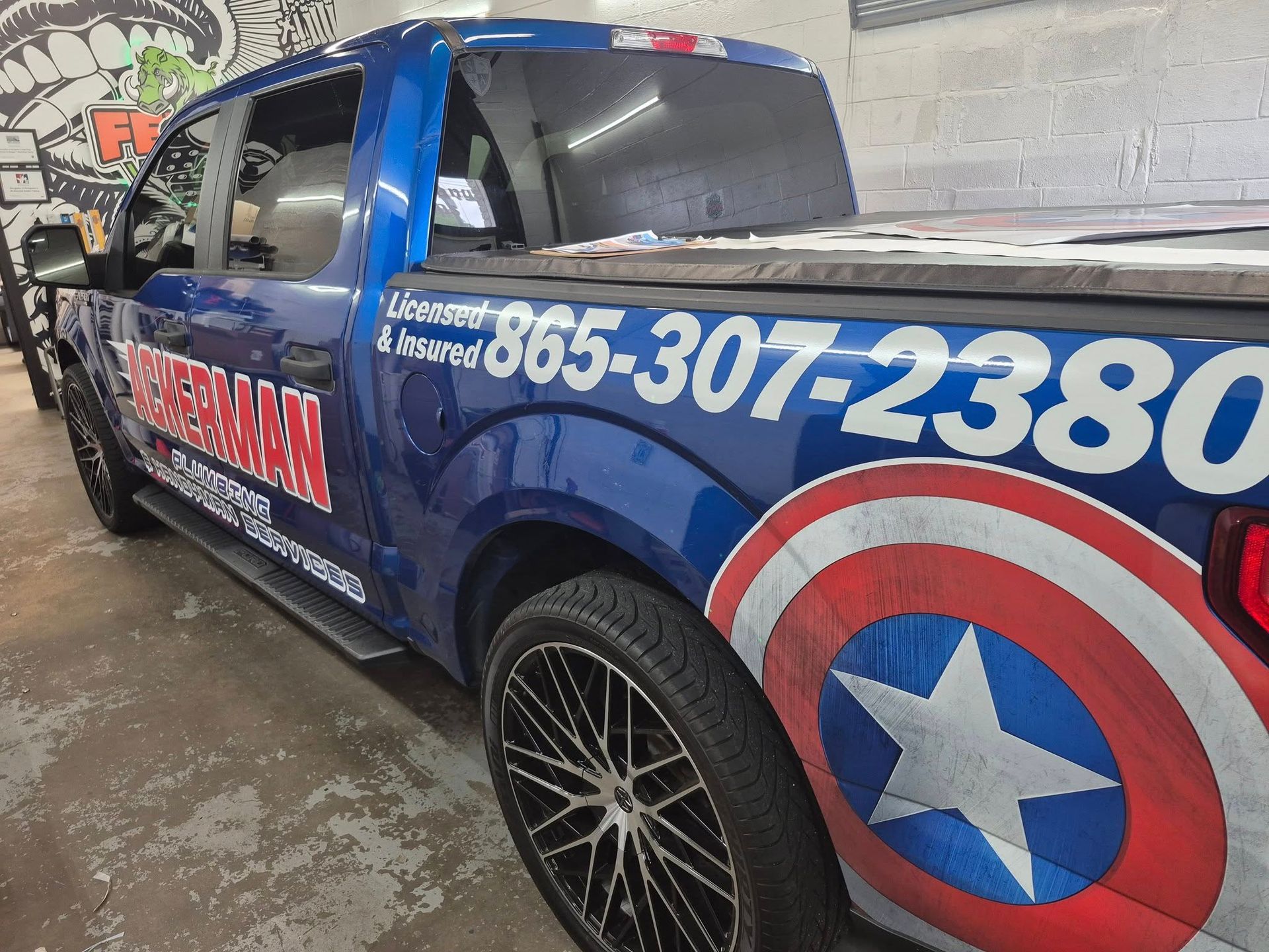 A blue truck with a captain america shield on the back