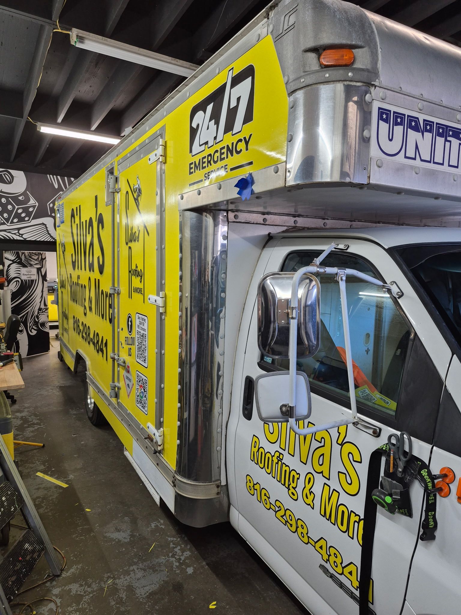 White box truck with yellow emergency signage and contact info.