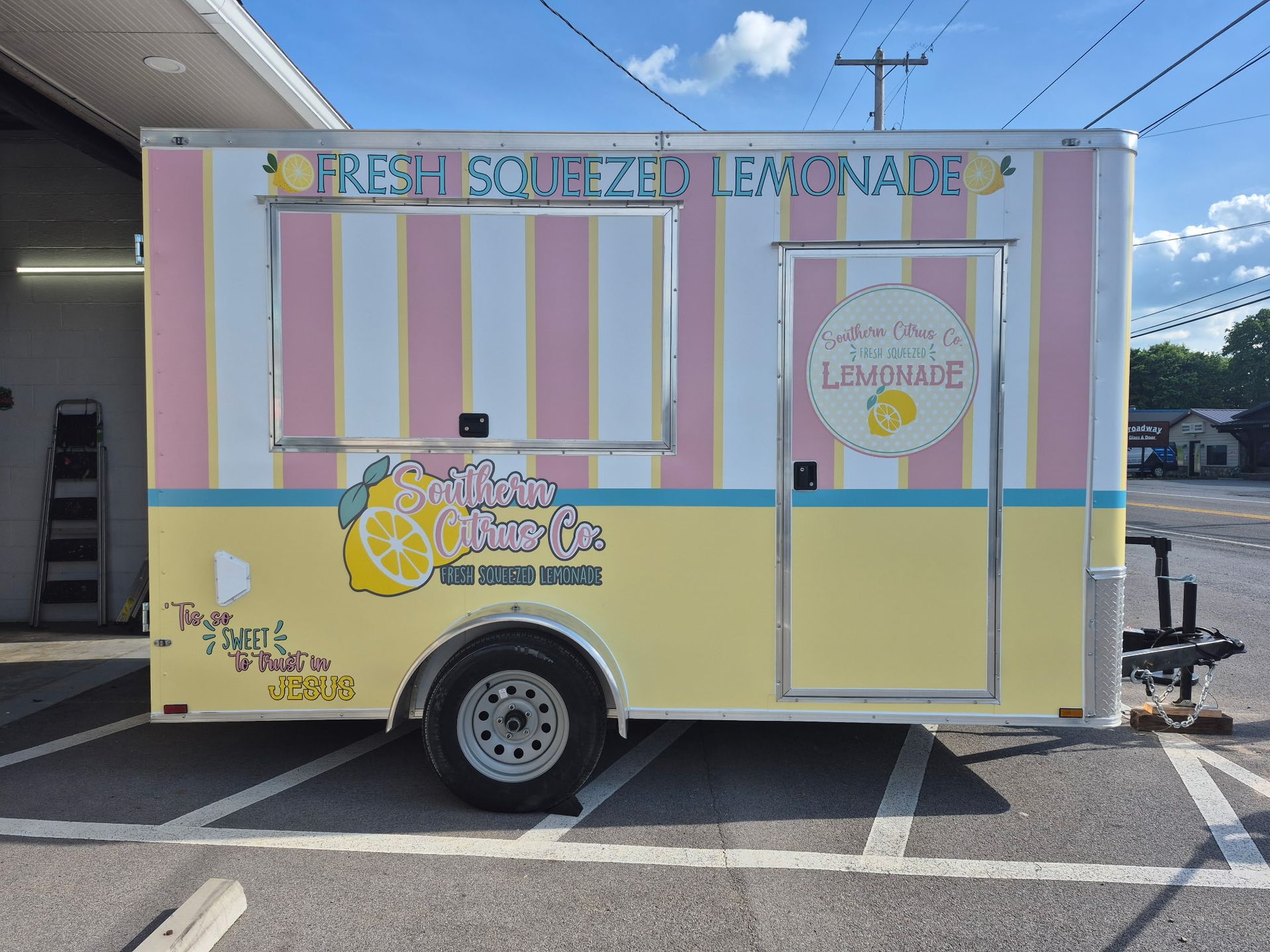 A lemonade trailer is parked in a parking lot.