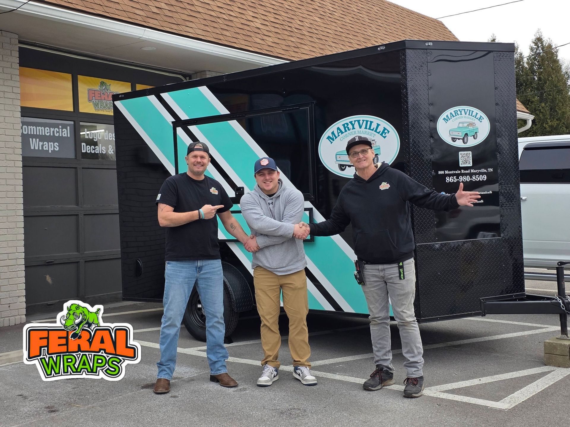Three people pose by a food trailer with teal stripes, 