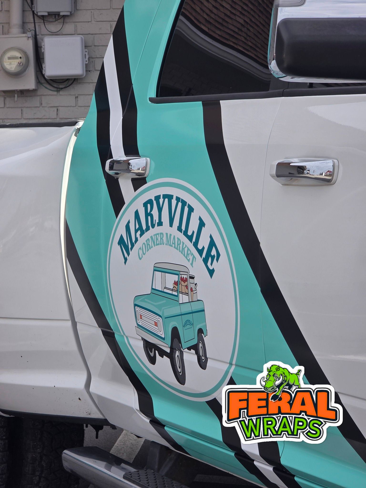 Truck door wrap with teal graphic, Maryville Clean Car Wash logo, and Feral Wraps logo.