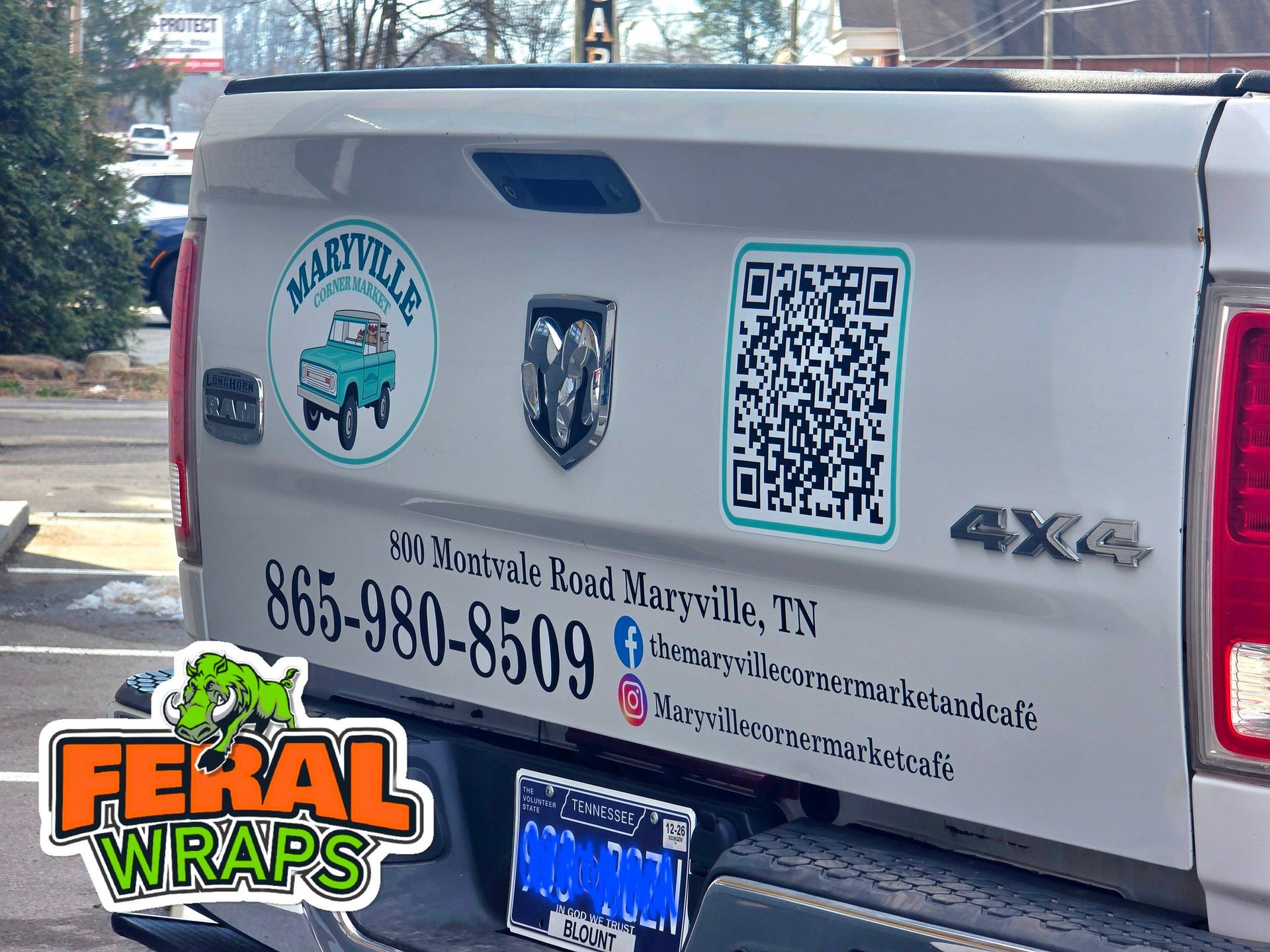 White pickup truck with business decals, including a QR code and contact info.