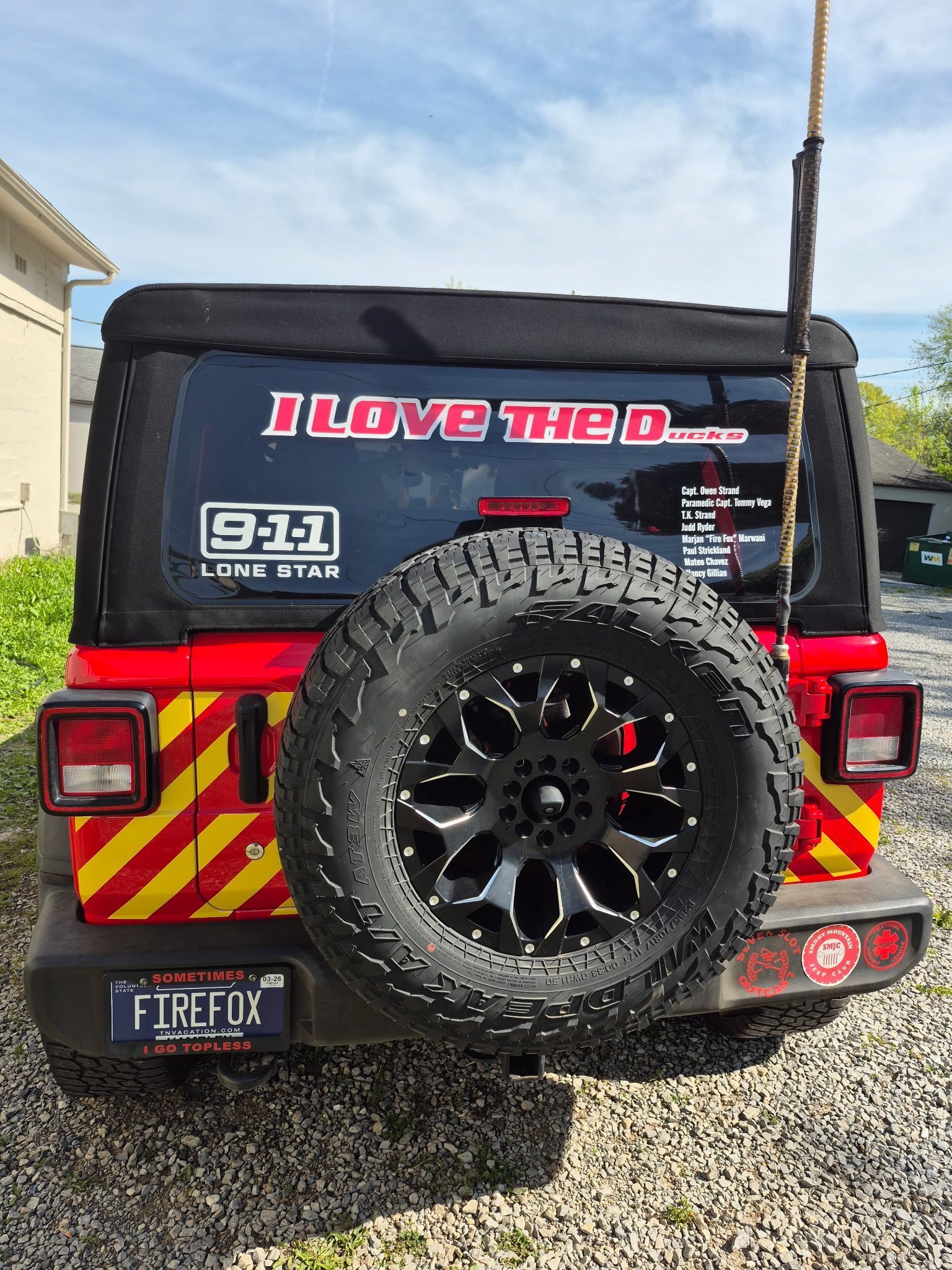 A red jeep with a sticker on the back window that says `` i love the d ''