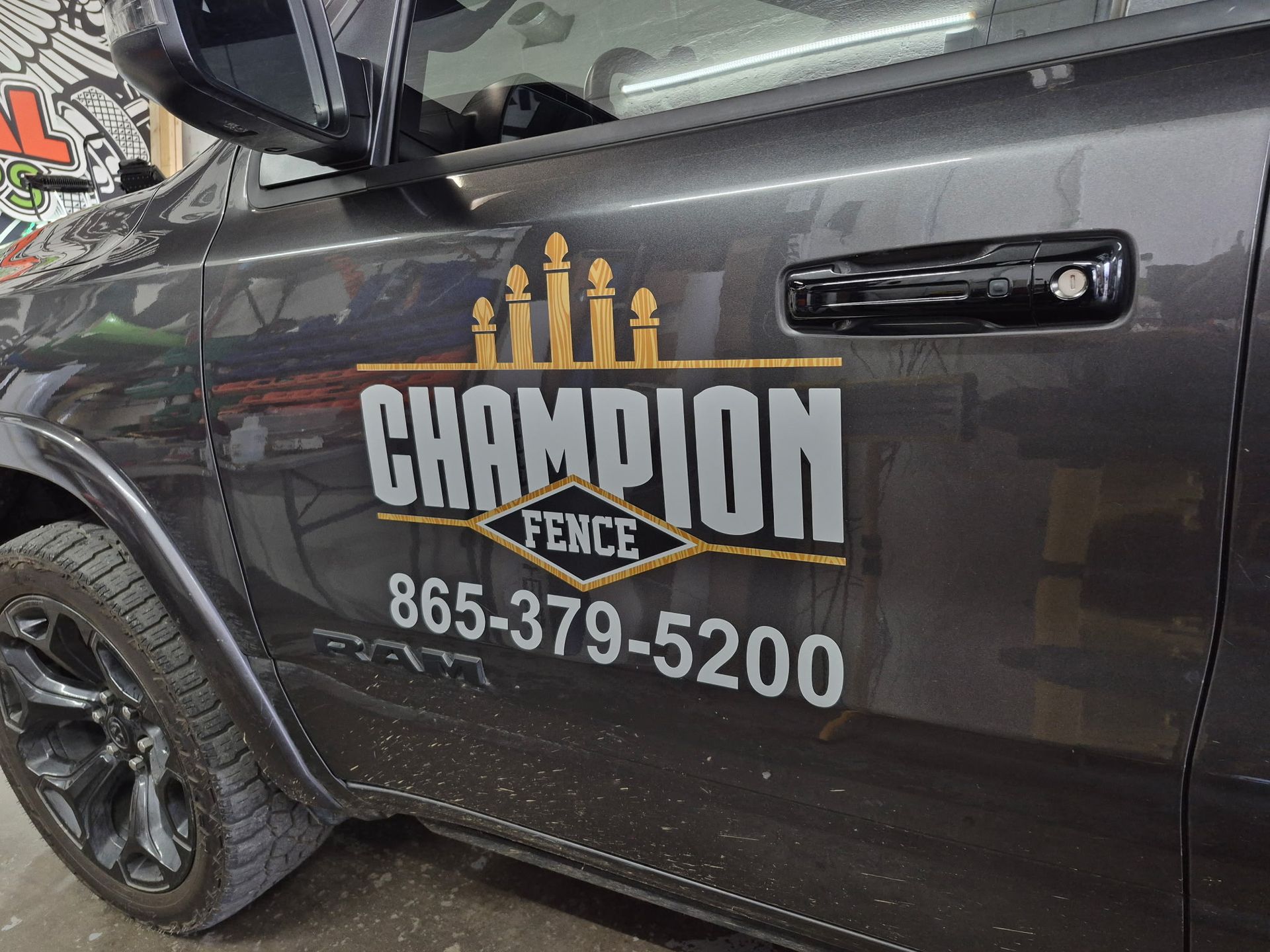 Gray truck with Champion Fence logo and phone number.