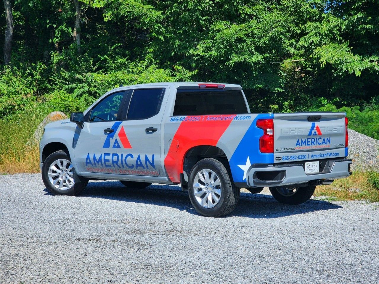An american truck is parked in a gravel lot.
