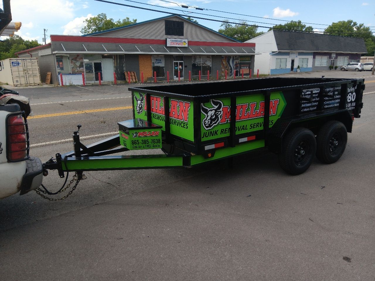 A trailer with a bull on it is being towed by a truck