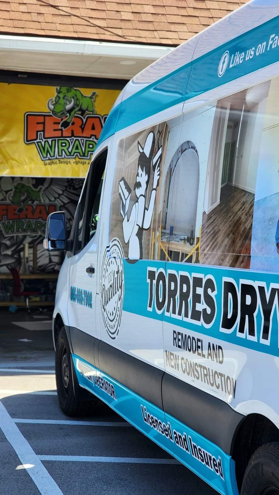 A blue and white van is parked in front of a building.