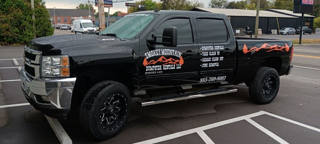 A black truck is parked in a parking lot.