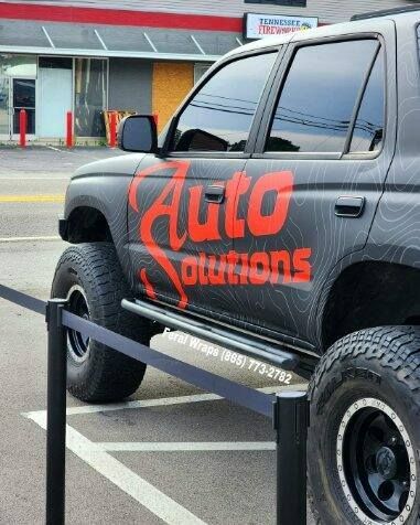 A black suv with the word auto solutions on the side