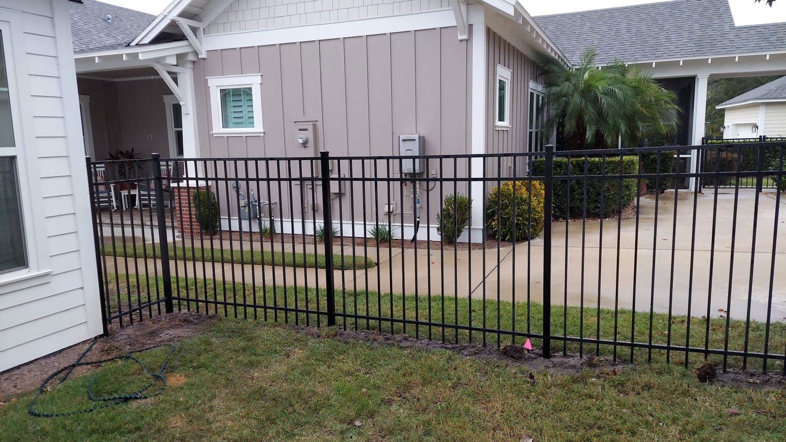 There is a black fence in front of a house.