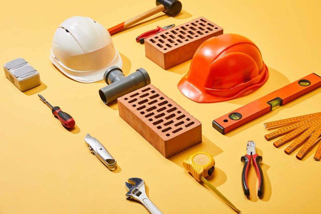A bunch of construction tools on a yellow background.