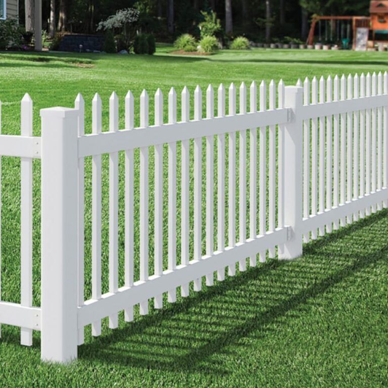 A white picket fence is sitting on top of a lush green lawn.