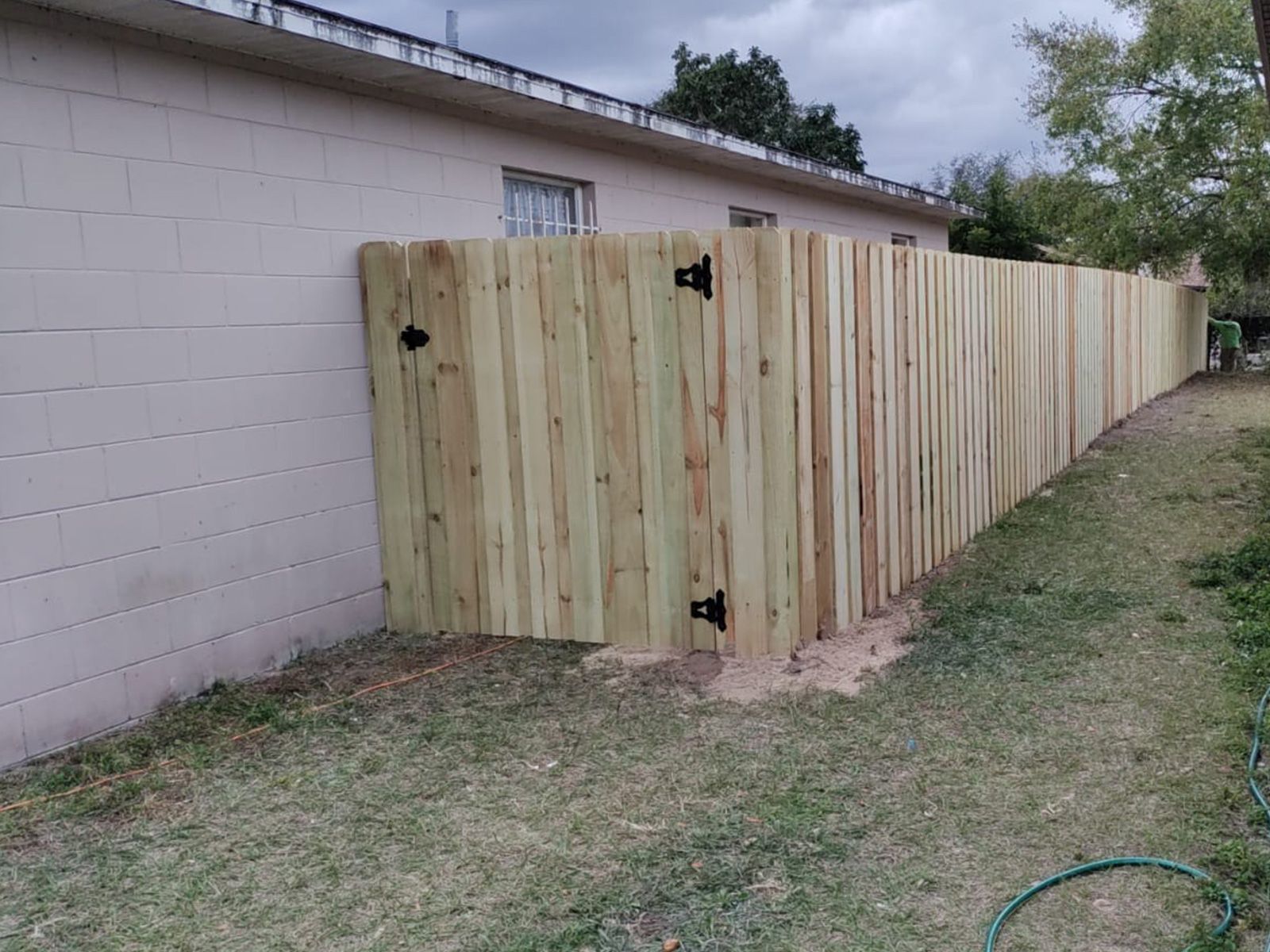 A wooden fence with a gate in the backyard of a house.
