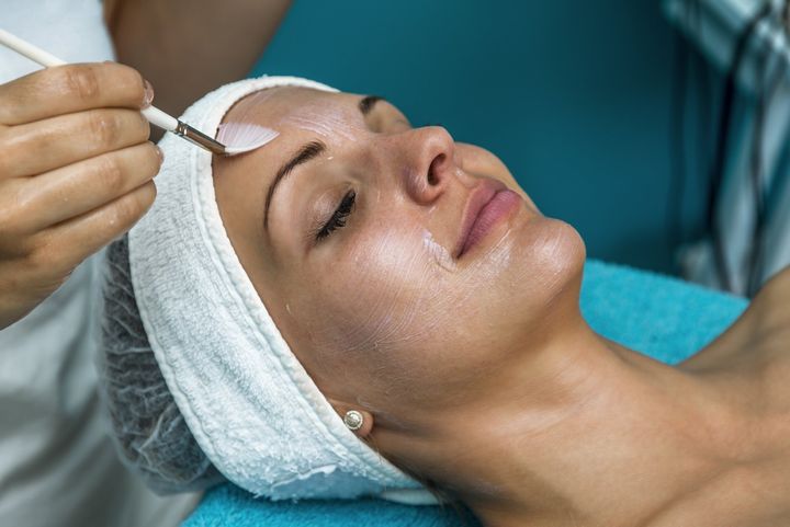 Image of a patient getting a chemical peel by a dermatologist.