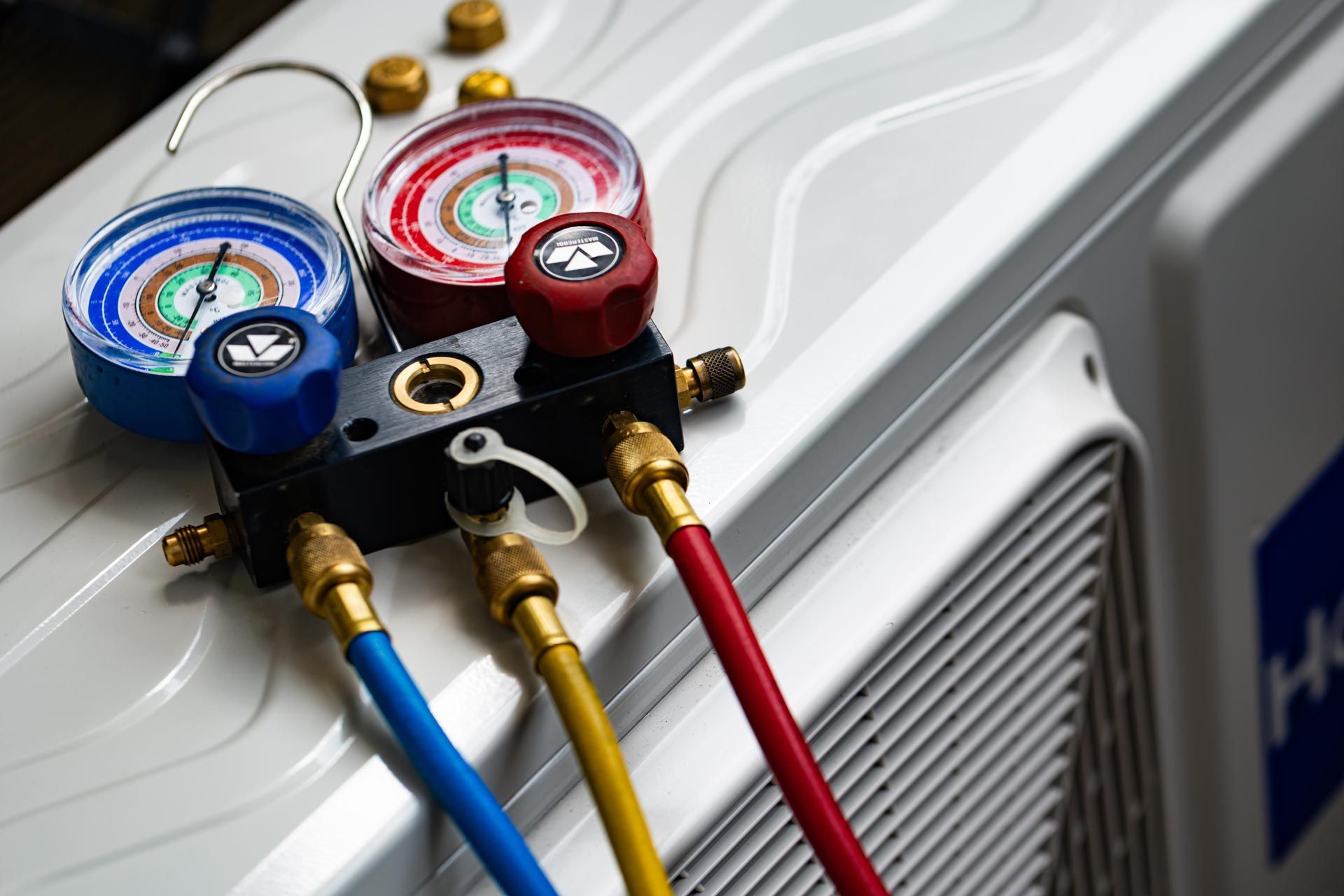 Manifold gauges on an AC unit used by an air conditioning contractor for system diagnostics.