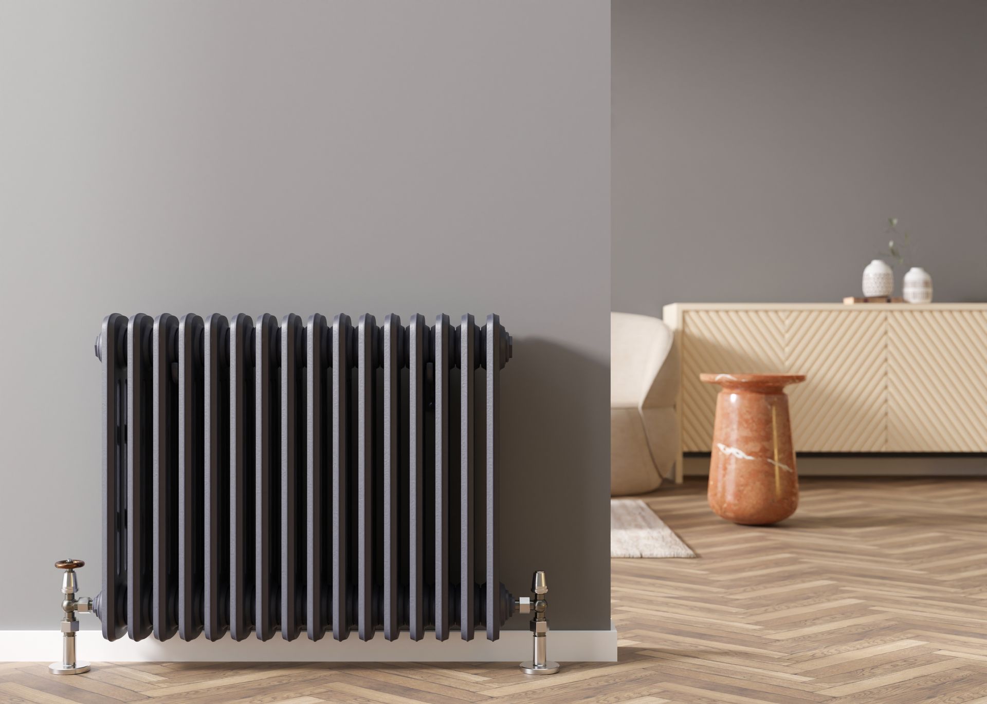 Black cast iron radiator against gray wall, interior scene with wooden flooring.