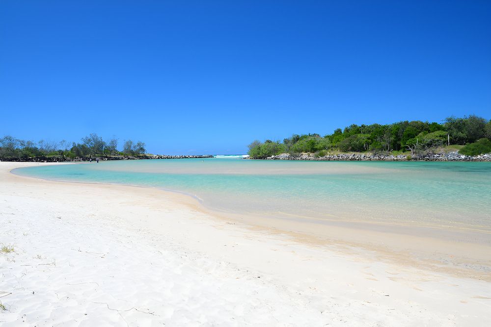 A White Sandy Beach With A Body Of Water — Brunswick Valley Door Centre in Pottsville, NSW