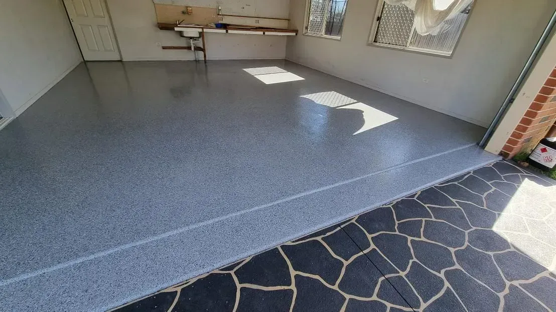 Grey Epoxy Garage Floor Next to Black Stone Outdoor Area — SRS Concreting In Ipswich, QLD