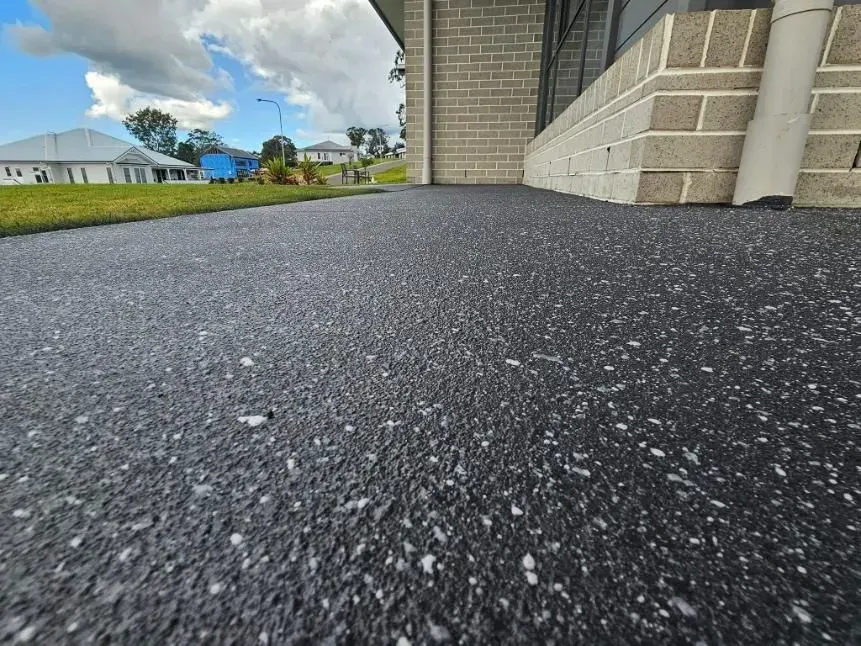 Close-up of a Dark, Speckled Driveway — SRS Concreting In Oakey, QLD