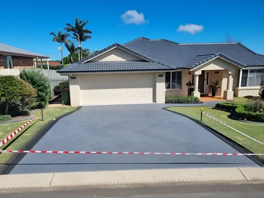 A House With a Newly Painted Gray Driveway, Blocked by Red and White Caution Tape — SRS Concreting In Warwick, QLD