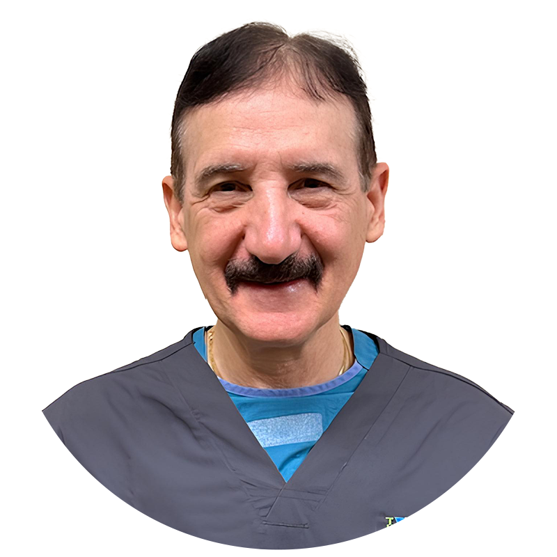 A man with a mustache is wearing a scrub and smiling.