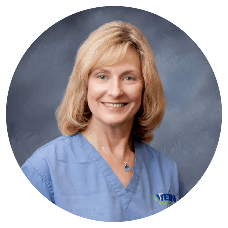 A woman wearing a blue scrub top with the word men on it