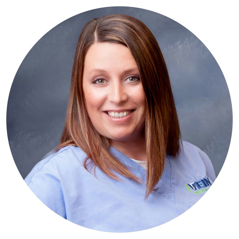 A woman wearing blue scrubs smiling in a circle