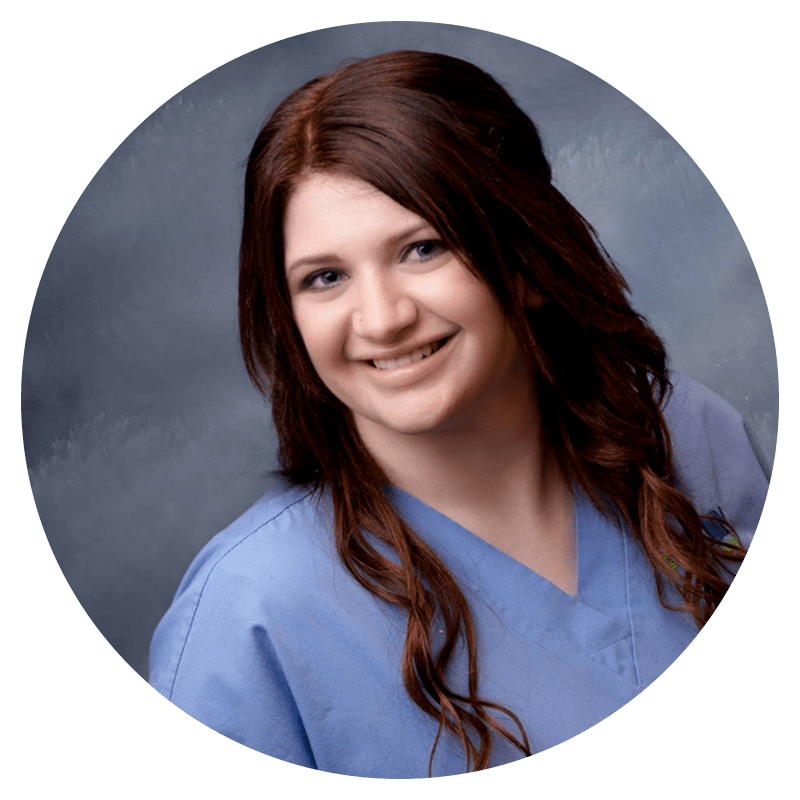 A woman in a blue scrub is smiling for the camera in a circle.