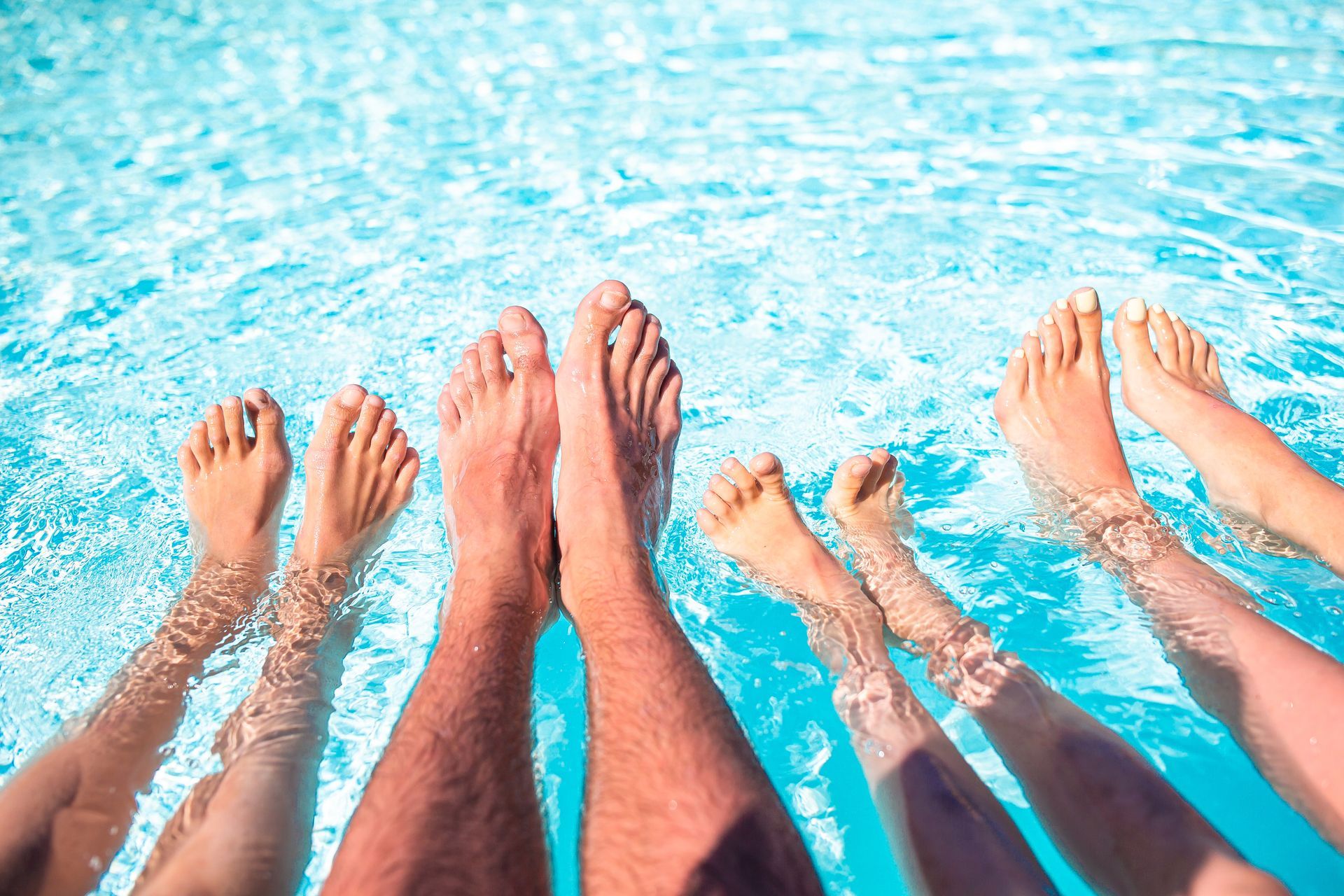 four legs sticking out of bright blue pool water