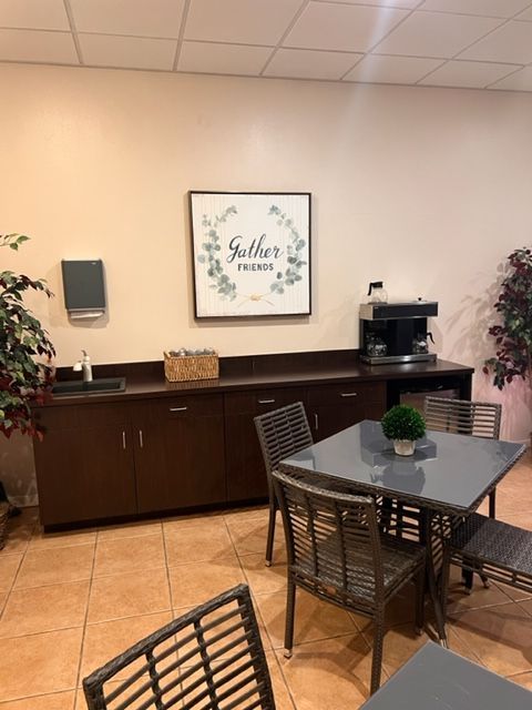 A room with a table and chairs and a sign that says gather