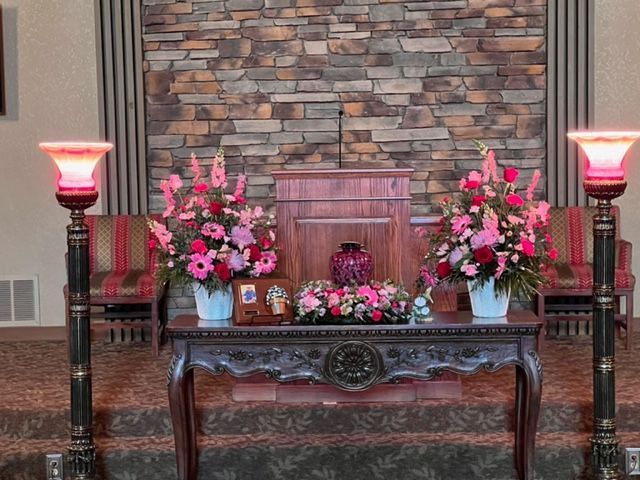 A table with flowers on it in front of a stone wall