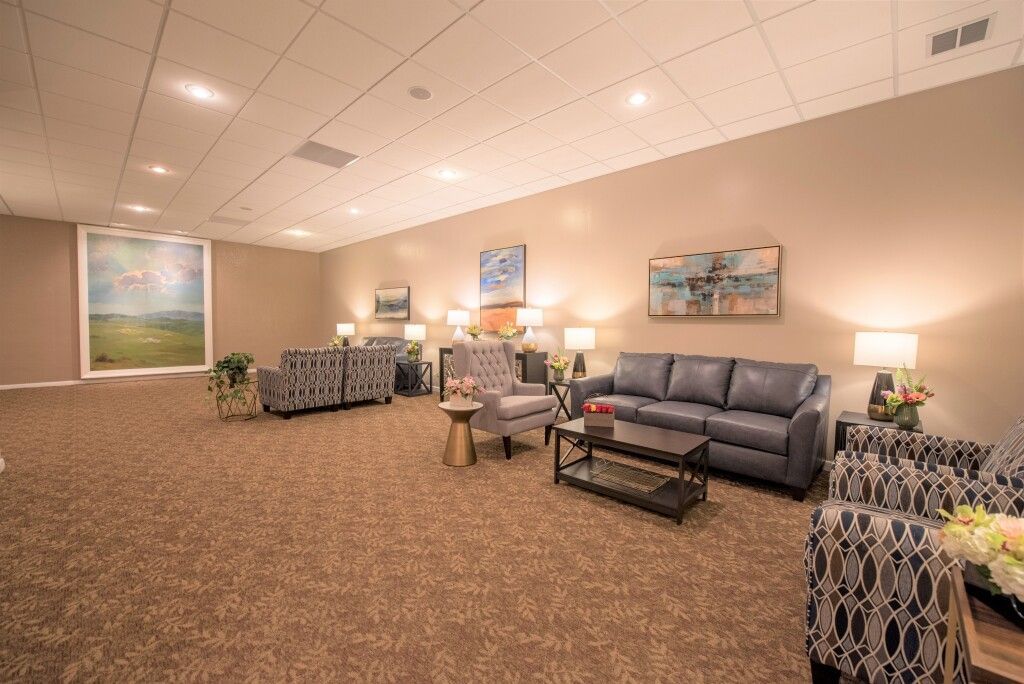 A living room with a couch , chairs , and a coffee table.