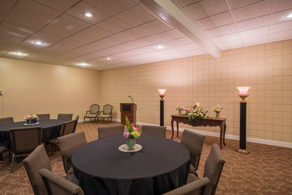 A conference room with tables and chairs and a podium.