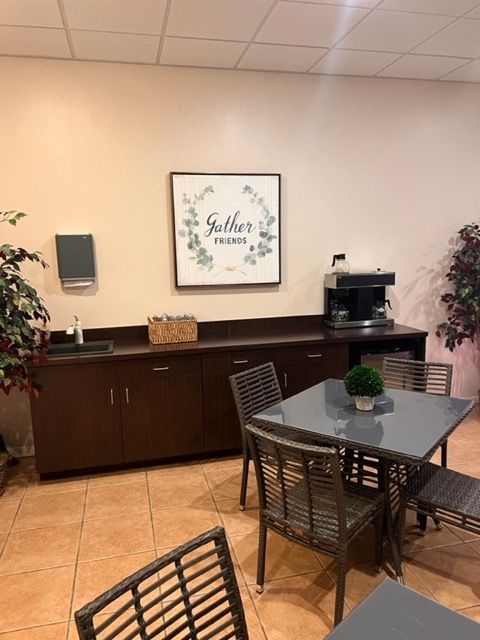 A room with a table and chairs and a sign that says gather