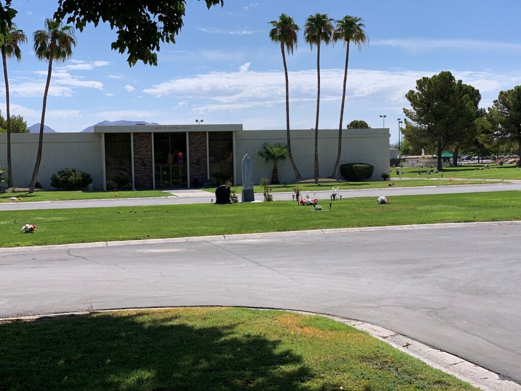 A large white building with palm trees in front of it