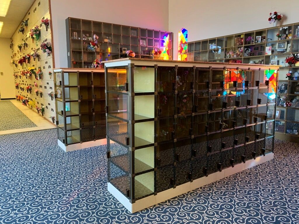 A room with a lot of shelves and a wall with flowers on it.