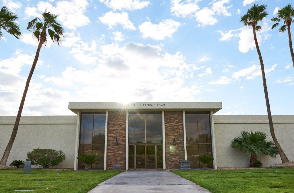 A large white building with palm trees in front of it
