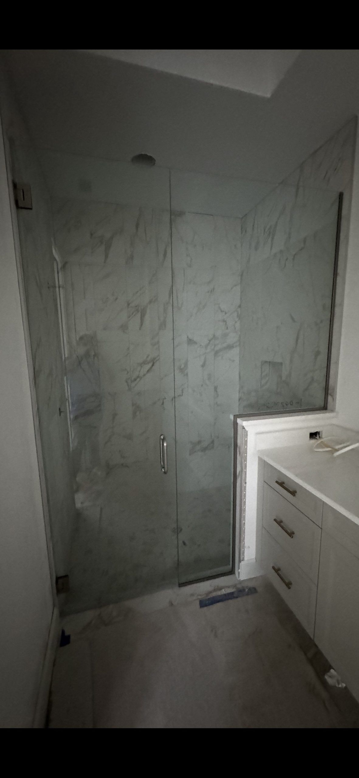 Shower with glass walls and a white vanity in a modern bathroom.